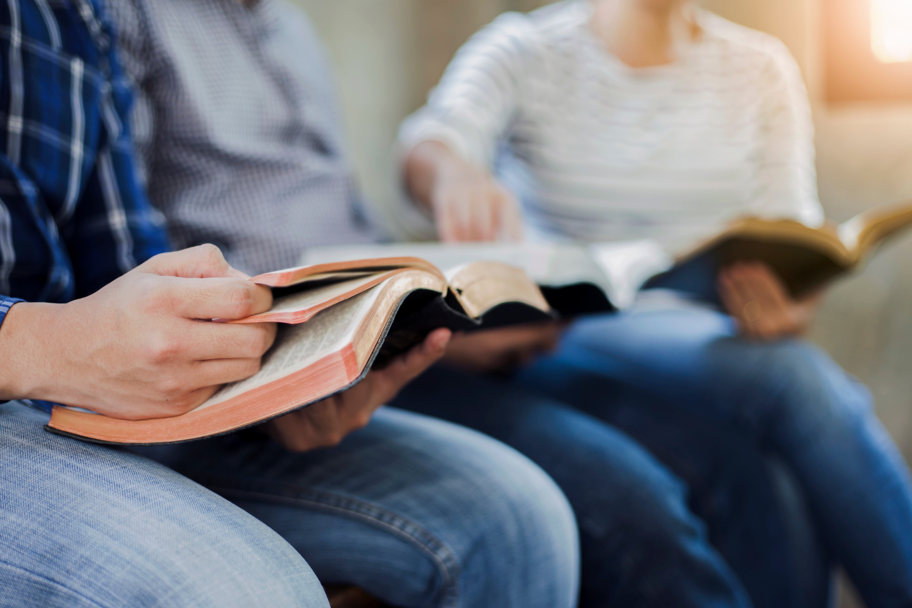 A person pointing to a verse in a Bible.